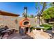 Outdoor pizza oven with seating area and wood storage, perfect for alfresco dining and entertaining guests at 4444 W Chama Dr, Glendale, AZ 85310