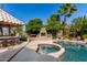 Backyard features a pool, spa, outdoor fireplace, and an outdoor kitchen perfect for entertaining guests at 4444 W Chama Dr, Glendale, AZ 85310