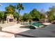 Inviting backyard pool with a built-in spa, rock waterfall feature, and outdoor fireplace for ultimate relaxation at 4444 W Chama Dr, Glendale, AZ 85310