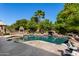 Enjoy the backyard pool with a rock waterfall feature, spa, lush landscaping, and outdoor fireplace at 4444 W Chama Dr, Glendale, AZ 85310