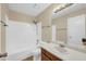 Bathroom showcasing a vanity with a sink, a large mirror, and a shower-tub combination at 4601 N 102Nd Ave # 1036, Phoenix, AZ 85037