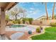 Inviting backyard with a stone pool, rock waterfalls, mature landscaping, and plenty of space for outdoor activities at 4806 E Thunderbird Dr, Chandler, AZ 85249