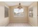 Inviting dining room with neutral paint, tile floors, bright windows, and a stylish hanging chandelier for a warm ambiance at 4806 E Thunderbird Dr, Chandler, AZ 85249