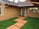 Inviting front entrance with lush synthetic grass, a secure screen door, and a modern pathway at 4807 E Everett Dr, Scottsdale, AZ 85254