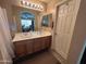 Bright bathroom featuring double sinks with wood cabinets and a large mirror at 4939 W Harwell Rd, Laveen, AZ 85339