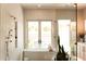 Bathroom featuring a soaking tub, glass shower, and a view to the exterior at 6114 E Calle Del Norte --, Scottsdale, AZ 85251