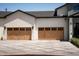 Two-car garage features custom doors, decorative lighting, and a modern driveway at 6114 E Calle Del Norte --, Scottsdale, AZ 85251