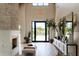 Bright living room with stone fireplace, hardwood floors, high ceilings, and black framed doors to landscaped backyard at 6114 E Calle Del Norte --, Scottsdale, AZ 85251