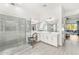 Well-lit bathroom featuring a walk-in shower, dual sinks, a makeup vanity, and access to the backyard at 6212 E Lonesome Trl, Cave Creek, AZ 85331