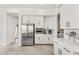 Open kitchen with stainless steel refrigerator, white cabinets, and tile flooring at 6212 E Lonesome Trl, Cave Creek, AZ 85331