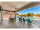 Inviting covered patio with travertine flooring, a ceiling fan, built-in BBQ, and view of the pool and backyard at 6212 E Lonesome Trl, Cave Creek, AZ 85331