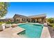 Inviting pool with travertine surround, landscaping, built-in BBQ, covered patio, and desert landscaping at 6212 E Lonesome Trl, Cave Creek, AZ 85331