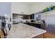 Contemporary kitchen featuring granite counters, dark cabinetry, stainless appliances and a large center island at 6228 W Caribbean Ln, Glendale, AZ 85306