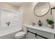 Bathroom featuring modern vanity, round mirror, and shower-tub combo at 6812 S 41St Pl, Phoenix, AZ 85042