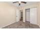 Bedroom featuring neutral walls, carpet flooring, ceiling fan, and closet with sliding doors at 6812 S 41St Pl, Phoenix, AZ 85042