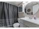 Bathroom with white vanity, round mirror, shower-tub combo with dark curtain, and tile floors at 9211 W Charleston Ave, Peoria, AZ 85382