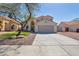 Single-Gathering home featuring desert landscaping, mature tree, and a spacious driveway at 9211 W Charleston Ave, Peoria, AZ 85382