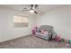 Bright, carpeted bedroom with a ceiling fan and a large window at 9627 W Reno View Dr, Peoria, AZ 85345