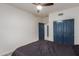 Bedroom featuring a ceiling fan, closet with blue paneled doors and en-suite bath at 9627 W Reno View Dr, Peoria, AZ 85345