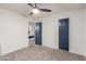 Neutral bedroom featuring carpeted floors, a window and a blue paneled door at 9627 W Reno View Dr, Peoria, AZ 85345