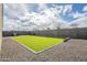 Green artificial turf and gravel in the backyard, surrounded by a gray block fence at 9965 W Devonshire Dr, Arizona City, AZ 85123