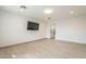 Large, brightly lit bedroom featuring sleek tiled floors and a mounted television at 9965 W Devonshire Dr, Arizona City, AZ 85123