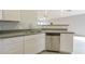 Bright kitchen with stainless steel dishwasher and white cabinetry, opening to living area at 9965 W Devonshire Dr, Arizona City, AZ 85123