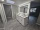 Modern bathroom with double vanity, lighted mirror, and gray wood-look tile flooring at 10328 E Michigan Ave, Sun Lakes, AZ 85248