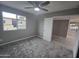 Well-lit bedroom featuring new carpet, window, ceiling fan, and a doorway leading to another room at 10328 E Michigan Ave, Sun Lakes, AZ 85248