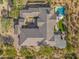 Aerial view showcases a meticulously landscaped property with a pool, covered patio, and well-manicured greenery at 10829 E Volterra Ct, Scottsdale, AZ 85262