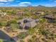 Aerial view of a luxurious residence nestled among other homes in the desert landscape at 10829 E Volterra Ct, Scottsdale, AZ 85262