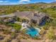 Aerial view of a property featuring a pool, a covered patio, and lush desert landscaping in the backyard at 10829 E Volterra Ct, Scottsdale, AZ 85262