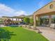 Beautiful backyard featuring a covered outdoor kitchen, artificial turf, and cozy seating area at 10829 E Volterra Ct, Scottsdale, AZ 85262