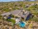 Beautiful aerial view of a private backyard with a custom pool, covered patio, and desert landscaping at 10829 E Volterra Ct, Scottsdale, AZ 85262