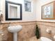 Elegant powder room featuring stylish pedestal sink, decorative mirror, and charming tile accents at 10829 E Volterra Ct, Scottsdale, AZ 85262