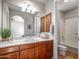 Well-lit bathroom features neutral walls, wood cabinets and trim, and a shower-over-tub enclosure at 10829 E Volterra Ct, Scottsdale, AZ 85262