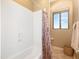 Bright bathroom features a clean shower-tub, with natural light from the window, and neutral tones at 10829 E Volterra Ct, Scottsdale, AZ 85262