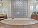 Bathroom with dual vanities, granite countertops, and a large tub with a privacy glass block window at 10829 E Volterra Ct, Scottsdale, AZ 85262