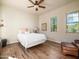 Comfortable bedroom features wood floors, ceiling fan, and view of the desert landscape through dual windows at 10829 E Volterra Ct, Scottsdale, AZ 85262