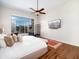 Bedroom with a large window, ceiling fan, TV, area rug and decorative pillows on the bed at 10829 E Volterra Ct, Scottsdale, AZ 85262