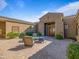 Warm courtyard seating area, complemented by lush shrubbery and a custom, double-door entrance at 10829 E Volterra Ct, Scottsdale, AZ 85262