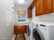 Well-equipped laundry room with front-load washer/dryer, ample cabinet space, and a convenient countertop at 10829 E Volterra Ct, Scottsdale, AZ 85262