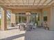 Covered outdoor patio with dining area, television and a pass-through window to the interior at 10829 E Volterra Ct, Scottsdale, AZ 85262