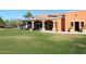 Clubhouse exterior patio with chairs, tables, and sun umbrellas overlooking the golf course at 10960 N 78 St, Scottsdale, AZ 85260