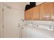 Functional laundry room with a washer, dryer, cabinetry, and access to the outdoors at 10960 N 78 St, Scottsdale, AZ 85260