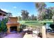 Relaxing outdoor patio featuring a fireplace, grill, seating, and views of the lush golf course at 10960 N 78 St, Scottsdale, AZ 85260