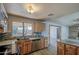 A warm kitchen with wooden cabinets, stainless appliances, and a granite countertop with a large window at 1205 W El Prado Rd, Chandler, AZ 85224