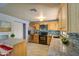 Modern kitchen featuring an island, stainless appliances, decorative backsplash, and neutral tile flooring at 1205 W El Prado Rd, Chandler, AZ 85224