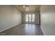 Empty living room featuring wood-look tile and plenty of natural light at 1205 W El Prado Rd, Chandler, AZ 85224