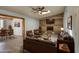 Inviting living room with brick fireplace, leather furniture, ceiling fan and seamless access to the dining room at 1205 W El Prado Rd, Chandler, AZ 85224